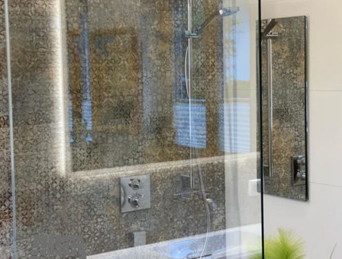 Ein extravagantes Badezimmer mit Dekor- und Holzoptikfliesen.