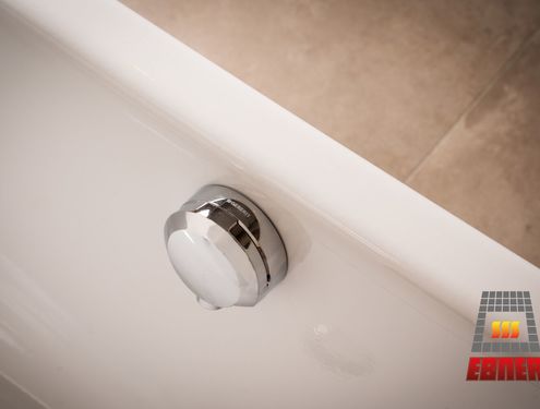 Modern, zeitlos und im Landhausstil. Durch die schlichten Fliesenfarben und den Badezimmermöbeln aus Holz wirkt das Badezimmer gemütlich und freundlich.