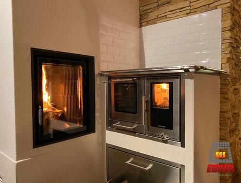 Ein kleiner Tischherd auf Dekorfliese mit eingebauter Holzlade und Sichtfenster für besondere Stimmung beim Kochen.