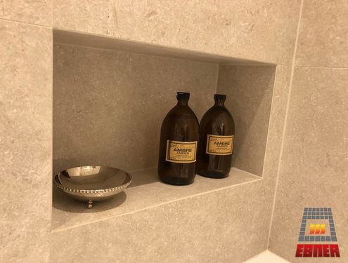 Das großzügige Badezimmer mit barrierefreier Dusche sowie Flur und Treppe wurden mit Großformatfliesen gestaltet, die farblich zum edlen Konzept des Hauses passen.