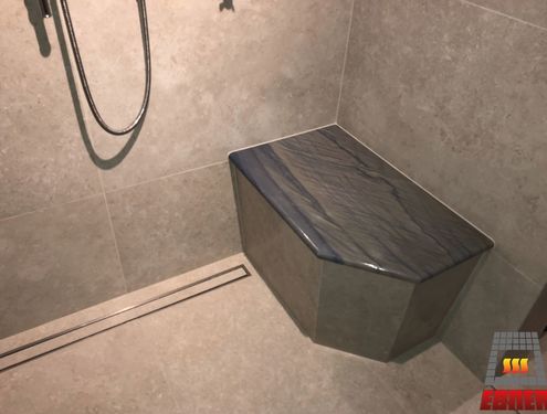 Das großzügige Badezimmer mit barrierefreier Dusche sowie Flur und Treppe wurden mit Großformatfliesen gestaltet, die farblich zum edlen Konzept des Hauses passen.