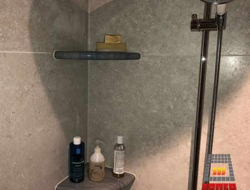 Das großzügige Badezimmer mit barrierefreier Dusche sowie Flur und Treppe wurden mit Großformatfliesen gestaltet, die farblich zum edlen Konzept des Hauses passen.